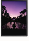 Een Silhouet Aan Het Zwembad Schilderij van een silhouet dat in de schemering bij een reflecterend waterlichaam staat, waarbij de lucht tinten paars en roze vertoont. Palmbomen sieren de achtergrond en versterken de rustige sfeer. De maansikkel is vaag zichtbaar aan de hemel, perfect voor wanddecoratie met een magnetisch ophangsysteem van CollageDepot.,Zwart-Zonder,Lichtbruin-Zonder,showOne,Zonder