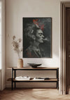 Een zwart-wit schilderij van een rokende vrouw, met een rode bloem in haar haar, hangt aan een lichtgekleurde muur boven een minimalistische consoletafel met behulp van een magnetisch ophangsysteem. Op de tafel staan een vaas met gedroogde bloemen, een open boek en een decoratieve schaal in een goed verlichte kamer.,Zwart