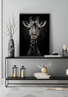 Een zwart-wit ingelijste foto van een giraffe hangt aan de muur boven een minimalistische zwarte consoletafel. Op de tafel staat een grote vaas met takken, enkele kleine decoratieartikelen, kaarsen en lantaarns. De achtergrond toont een subtiele lichtgrijze muur. Het spijt me als het erop lijkt dat de productbeschrijving van CollageDepot aab 209 AI ontbreekt in uw verzoek.,Zwart