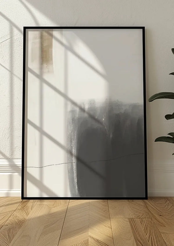 Een ingelijst Simplicity-schilderij van CollageDepot met een wit en donkergrijs verloop leunend tegen een gebroken witte muur. Het zonlicht werpt schaduwen door ruiten op het schilderij. Aan de rechterkant is een gedeelte van een groene plant zichtbaar en de vloer heeft een visgraatpatroon: perfecte wanddecoratie voor elke kamer.
