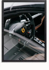 Een ingelijste foto met een close-up van het interieur van een luxe auto. De afbeelding concentreert zich op het stuur, waarop een prominent embleem van een steigerend paard staat, wat aangeeft dat het voertuig een Ferrari is. Het dashboard en de bedieningsknoppen zijn ook zichtbaar, waardoor het een prachtig CollageDepot Ferrari Cockpit Schilderij is.,Zwart-Zonder,Lichtbruin-Zonder,showOne,Zonder