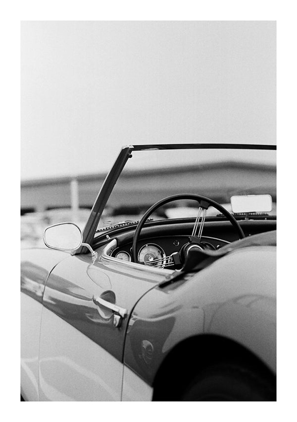 Zwart-witfoto van het interieur van de aaa 007-auto's van CollageDepot, met een gedetailleerd zicht op het stuur en het dashboard.-