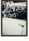 Een ingelijste foto van een klassieke witte Ferrari. De afbeelding toont een close-up van de bestuurderszijde, waarbij de nadruk ligt op de klassiek houten stuurinrichting en het dashboard door het open raam. De interieurdetails worden benadrukt tegen een onscherpe achtergrond. Dit prachtige stuk staat bekend als het Witte Oldtimer Ferrari Schilderij van CollageDepot.,Zwart-Zonder,Lichtbruin-Zonder,showOne,Zonder