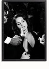 Zwart-witfoto van een vrouw met gekruld haar die een sigaret rookt. Er zijn meerdere handen te zien die aanstekers aanbieden om haar sigaret aan te steken. De vrouw, gekleed in een donker mouwloos topje, staat centraal in dit Glamorous Lana del Rey rokende schilderij van CollageDepot, perfect voor je wanddecoratie met een magnetisch ophangsysteem.