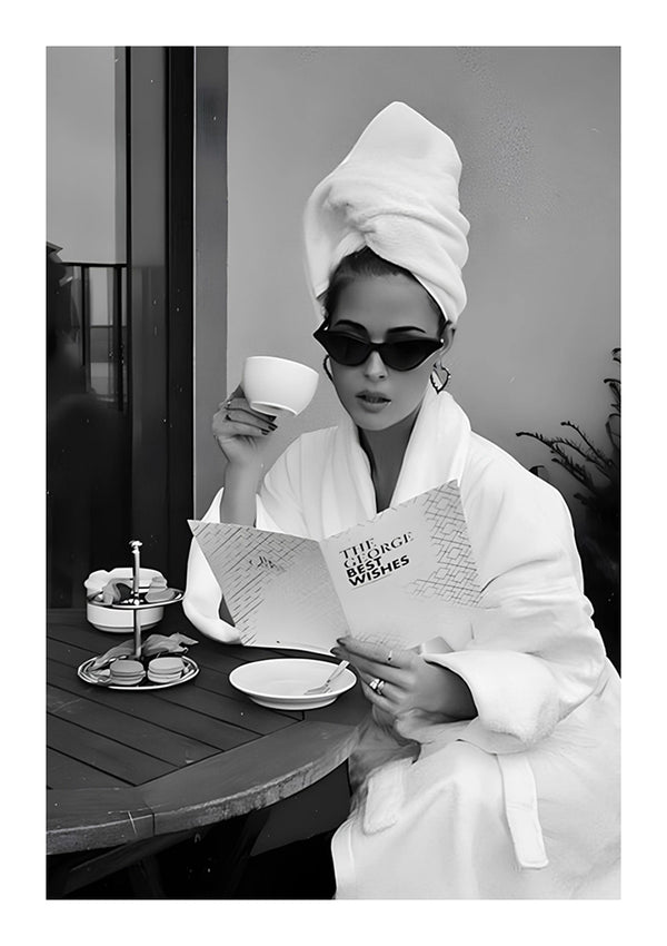Een vrouw in een wit gewaad en een handdoek-tulband leest een krant met het opschrift 'Three Magic Wishes', terwijl ze een kop koffie op een balkon houdt, met een ontbijtblad naast haar. De afbeelding is in zwart-wit.ab 002 - zwart-wit van CollageDepot-