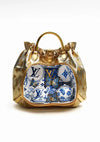 Een Louis Vuitton Gouden Tas Met Kopjes Schilderij van CollageDepot heeft een transparant gedeelte met blauw en wit porselein, inclusief porseleinen schaaltjes en theekopjes met vlindermotieven en het iconische Louis Vuitton-logo.