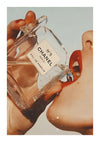 Een close-up van een persoon die een bijna lege fles CollageDepot bb 001 - modeparfum dicht bij zijn mond houdt, met waterdruppels op de fles en zijn vingers. De achtergrond is zacht blauw.-