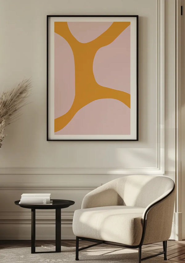 Een Organische Vorm Schilderij van CollageDepot met oranje en beige vormen hangt aan een lichtgekleurde muur boven een beige fauteuil. Naast de stoel staat een klein zwart bijzettafeltje met daarop een stapel boeken. Links is gedeeltelijk een gedroogde plant in een vaas zichtbaar, wat de elegante wanddecoratie nog extra benadrukt.,Zwart