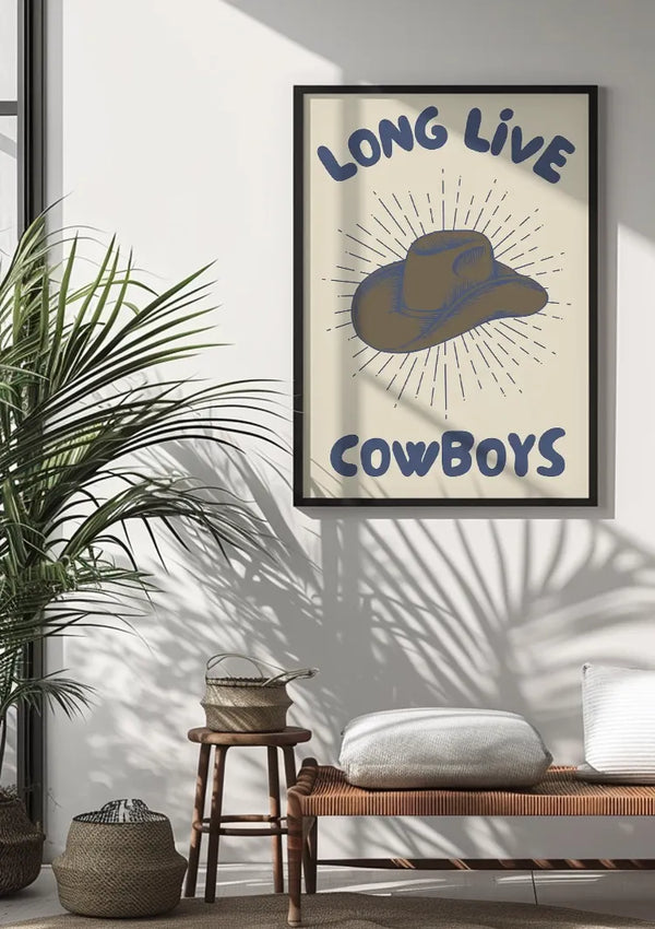 Op een ingelijste CollageDepot Long Live Cowboys Schilderij aan de muur staat "LONG LIVE COWBOYS" met een illustratie van een iconische cowboyhoed. Het maakt deel uit van een minimalistisch kamerdecor met een houten bank met kussens, een geweven mand en een potplant. Het zonlicht filtert door een onzichtbaar raam en versterkt de wanddecoratie.,Zwart