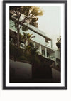 Een foto van een modern huis met meerdere verdiepingen, grote glazen ramen en balkons, omgeven door bomen en weelderig groen. Het beeld, omlijst met een zwarte rand, lijkt op een verfijnd schilderij van CollageDepot Villa Marbella en lijkt op een heuvel gelegen.