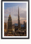 Een ingelijste foto van een stadsgezicht in de schemering, met de Burj Khalifa en andere omliggende wolkenkrabbers in Dubai, nu verkrijgbaar als CollageDepot's stijlvolle Uitzicht Wolkenkrabbers En Busj Khalifa Schilderij wanddecoratie. De lucht is gedeeltelijk bewolkt met een zachtblauwe en roze tint. De stad wordt verlicht met kunstlicht, wat de moderne architectonische scène versterkt.,Zwart-Met,Lichtbruin-Met,showOne,Met