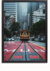 Een gele tram rijdt door een steile, mistige straat in San Francisco tussen hoge gebouwen. De straat heeft rode markeringen die een bus- en taxibaan aangeven, terwijl aan weerszijden bomen en geparkeerde auto's staan. De tramsporen leiden naar de horizon. Deze scène zou een prachtig Tram In San Francisco-schilderij zijn voor je wanddecoratie van CollageDepot.,Zwart-Zonder,Lichtbruin-Zonder,showOne,Zonder