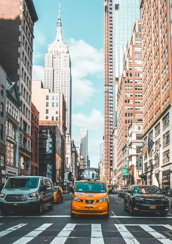 Een bruisend straatbeeld in New York City met een gele taxi op de voorgrond en het Empire State Building in de verte onder een strakblauwe hemel is te vinden in de collectie baa 039 - landen en steden van CollageDepot.-