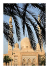 Een architectonisch aanzicht van een moskee met meerdere koepels en twee hoge minaretten, die lijkt op een prachtig Moskee Met Sierlijke Structuur Schilderij van CollageDepot. Palmbladeren op de voorgrond verduisteren het gebouw gedeeltelijk, terwijl de helderblauwe lucht dit pittoreske tafereel compleet maakt.-