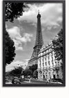Zwart-witfoto van de Eiffeltoren in Parijs, Frankrijk. De toren staat prominent op de achtergrond, omgeven door bomen en klassieke Parijse gebouwen. Op de voorgrond zijn auto's en voetgangers te zien op straat, waardoor een perfecte Elegante Gebouwen Met De Eiffeltoren Schilderij van CollageDepot ontstaat voor uw wanddecoratie.,Zwart-Zonder,Lichtbruin-Zonder,showOne,Zonder
