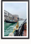 Een ingelijste foto legt een uitzicht vast vanuit een gondel op een kanaal in Venetië, Italië. Het beeld, perfect als wanddecoratie, toont andere gondels op het water, met historische gebouwen langs het Canal Grande onder een bewolkte hemel. De sierlijke details van het interieur van de gondel zijn ook zichtbaar. Deze prachtige scène is ingekapseld in het Gondels In Venetië Schilderij van CollageDepot.,Zwart-Met,Lichtbruin-Met,showOne,Met