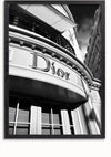Een zwart-witfoto legt de buitenkant van een gebouw vast, waarop prominent een groot, stijlvol zwart-wit Dior-logoschilderij van CollageDepot te zien is. Het perspectief kijkt omhoog naar het gebouw en benadrukt architectonische details en een gedeeltelijk bewolkte lucht erboven.,Zwart-Zonder,Lichtbruin-Zonder,showOne,Zonder