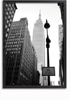 Zwart-witfoto van een stadsscène met hoge gebouwen, met een grote, prominente wolkenkrabber in het midden. Op de voorgrond staat een straatlantaarn en een bord met de tekst "Busbanen foto afgedwongen." Het perspectief kijkt naar boven, waardoor het perfect is als CollageDepot's Streets of New York schilderij met een magnetisch ophangsysteem.