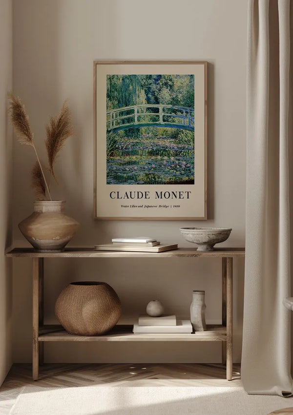Een minimalistische kamer met een ingelijst CollageDepot Claude Monet Waterlelies en Japanse brugschilderij boven een houten plank. Op de plank staan decoratieve voorwerpen, waaronder vazen met gedroogde planten, een geweven mand, een kom en een klein keramiekstuk. Naast de plank hangen lichtgordijnen die de serene sfeer compleet maken.,Lichtbruin
