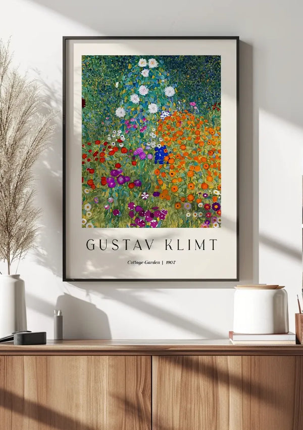 Een CollageDepot Gustav Klimt Cottage Garden Schilderij, gedateerd 1907, is een prachtig schilderij dat aan een witte muur boven een houten kast hangt. Decoratieve items, waaronder een vaas met pampasgras en een kleine pot, zijn vakkundig gerangschikt als aanvulling op dit prachtige kunstwerk.,Zwart