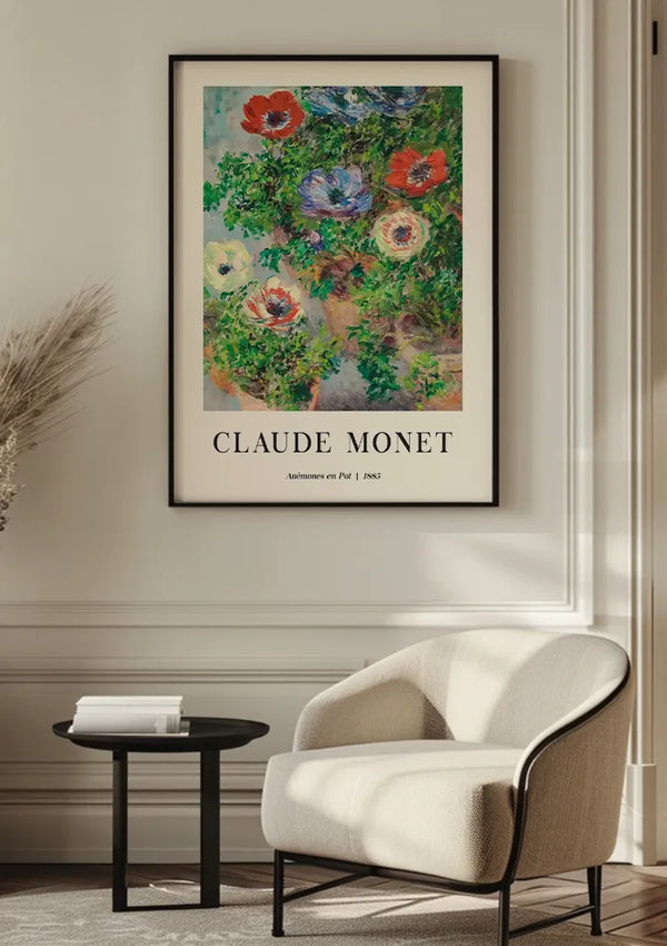 Een moderne kamer met witte muren met een schilderij van Claude Monet Anemones En Pot van CollageDepot met het opschrift "Anemones En Pot" uit 1885. De kamer is voorzien van een stoel met witte kussens, een kleine zwarte tafel met boeken en een arrangement van gedroogde planten in de hoek, waardoor een elegante wanddecoratie.,Zwart