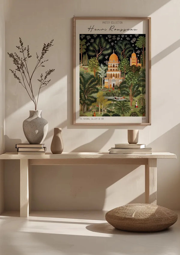 Een ingelijst schilderij met de titel "H. Rousseau - The National Gallery Of Art Orientals Schilderij" van CollageDepot wordt aan een lichtgekleurde muur boven een houten bank gehangen. Op de bank staan vazen en boeken. Op de voorgrond ligt een rond kussen op de grond. Licht stroomt vanaf de linkerkant de kamer binnen en verlicht de wanddecoratie met elegantie.,Lichtbruin
